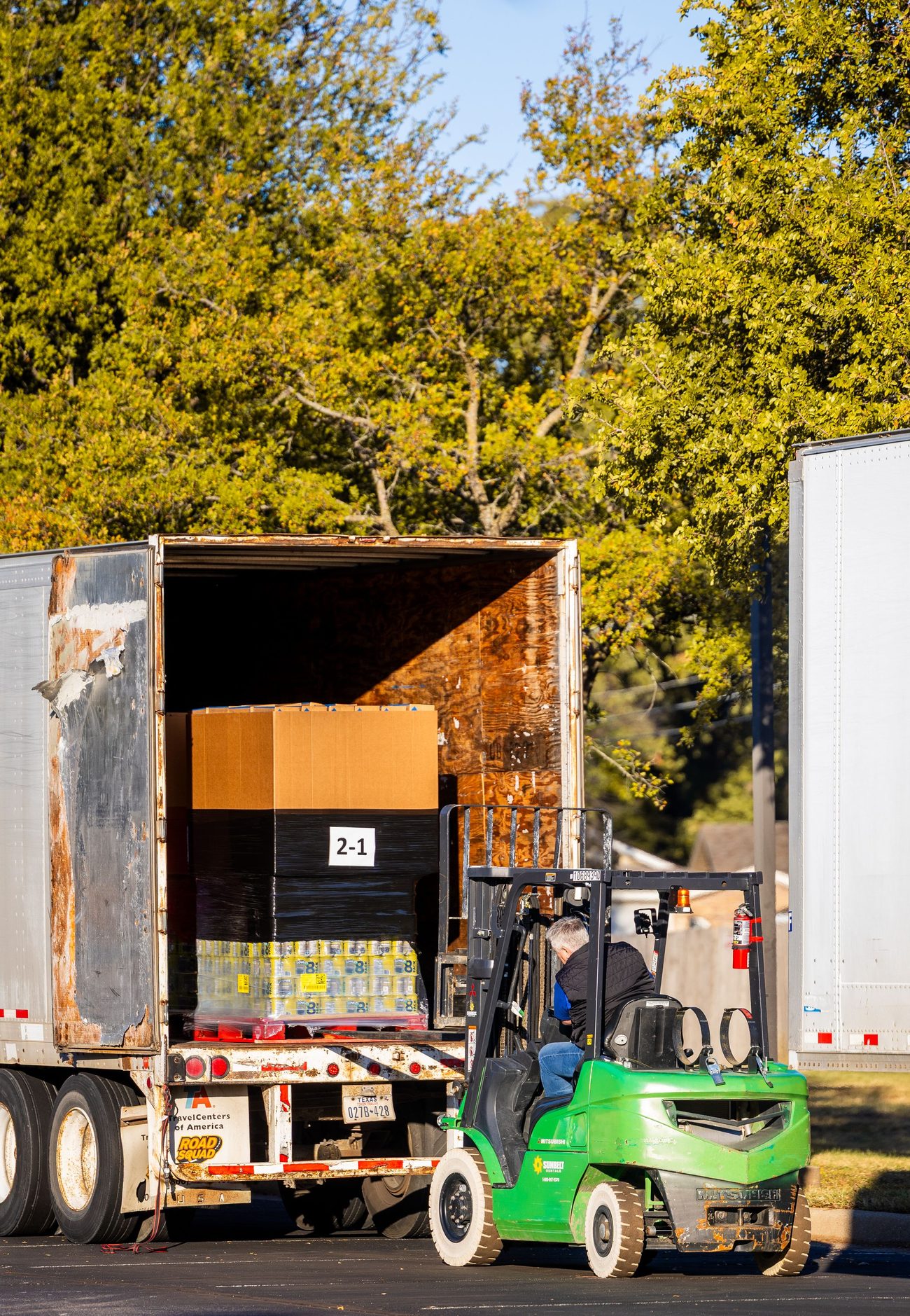 Forklift transferring palletized freight into a trailer