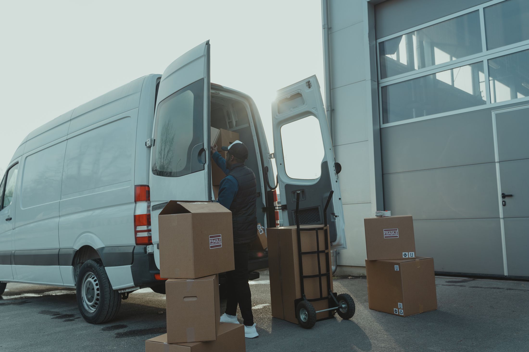 Courier loading a cargo van at a warehouse